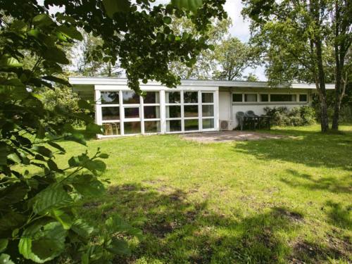 una casa blanca con un patio con césped en Holiday Home Thara - 100m from the sea in SE Jutland by Interhome, en Sønderby
