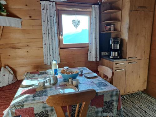 eine Küche mit einem Tisch mit einer Schüssel Essen drauf in der Unterkunft Chalet Nasenalmhütte by Interhome in Hippach