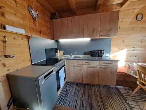 a kitchen with a stove and a sink in a cabin at Chalet Nasenalmhütte by Interhome in Hippach