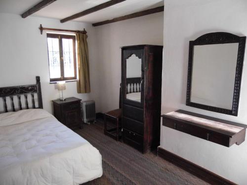 a bedroom with a bed and a dresser and a mirror at Inka Tambo Hacienda in Cusco