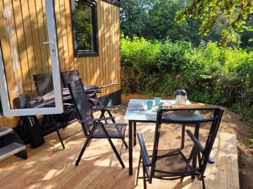 stół i krzesła na tarasie obok kabiny w obiekcie Holiday Home Soul & Forest by Interhome w mieście Wemding