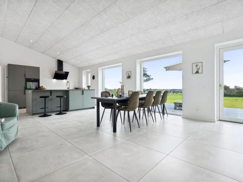 a kitchen and dining room with a table and chairs at Holiday Home Landuin - 30km from the sea by Interhome in Løgumkloster