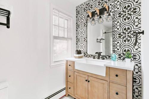 een badkamer met een wastafel en een spiegel bij Fire pit ~ Game Room ~ near NYC ~ Modern Luxury in New Rochelle