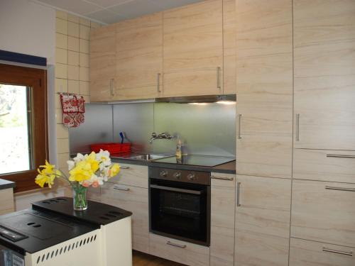 a kitchen with wooden cabinets and a sink and a stove at Holiday Home Clelia by Interhome in Camedo
