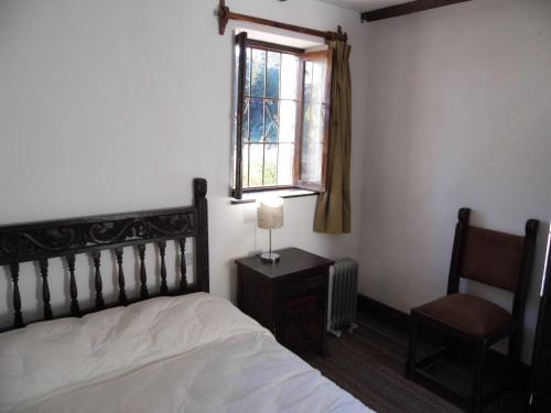 a bedroom with a bed and a window and a chair at Inka Tambo Hacienda in Cusco