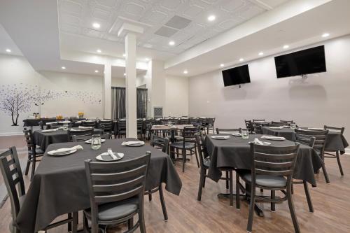 a dining room with tables and chairs and a flat screen tv at Clarion Hotel & Suites BWI Airport North in Baltimore