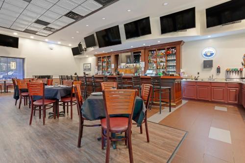 a restaurant with tables and chairs and a bar at Clarion Hotel & Suites BWI Airport North in Baltimore
