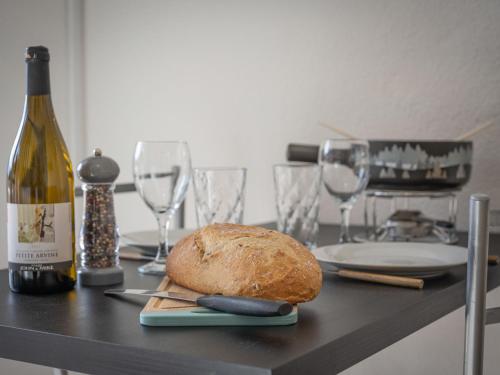 een tafel met een fles wijn en een brood bij Studio Beau séjour 15 by Interhome in Ovronnaz