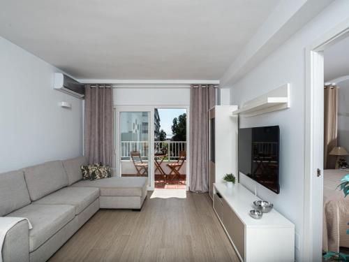 uma sala de estar com um sofá e uma televisão em Apartment Sol de Marbella by Interhome em Marbella
