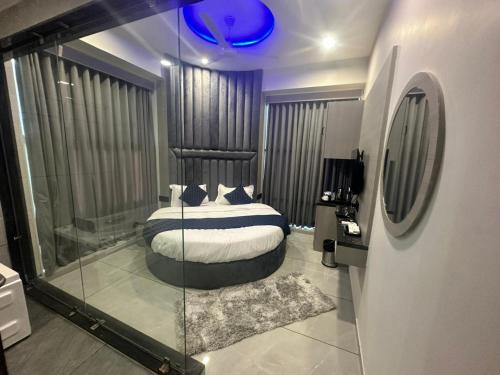 a bedroom with a bed and a glass wall at HOTEL ASIANA SKY Motera Ahmedabad in Ahmedabad