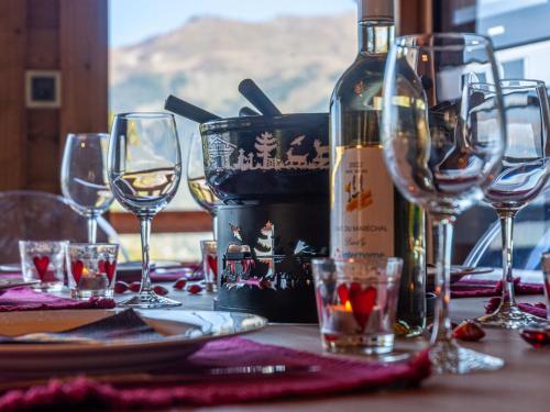 a table with wine glasses and a bottle of wine at Chalet Skyfall by Interhome in Les Collons