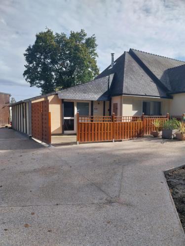 a house with a wooden fence in the driveway at Gite de l'olivier in Rohan