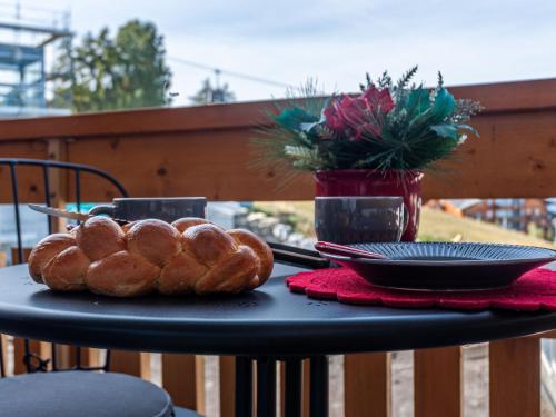 a table with a plate of loaves of bread on it at Apartment Victoria 1 D2 by Interhome in Nendaz