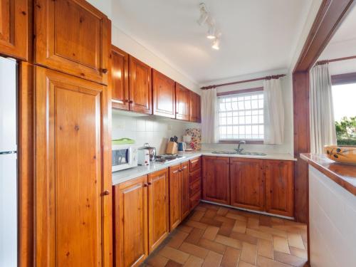 uma grande cozinha com armários de madeira e uma janela em Apartment Melis II by Interhome em Pals