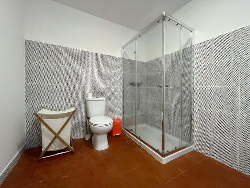 a bathroom with a toilet and a glass shower at Casa do Tanque in Vila Nova de Famalicão