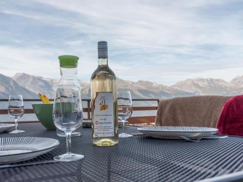 a bottle of wine sitting on a table with glasses at Apartment Olympic C7 by Interhome in Nendaz