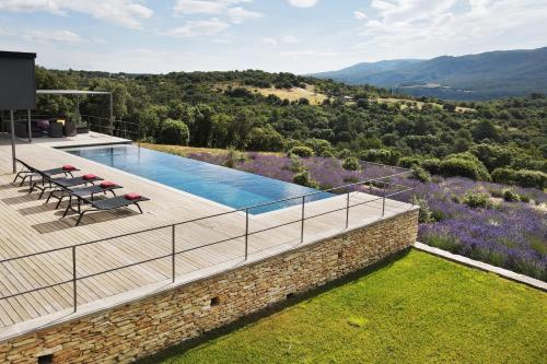 une villa avec une piscine sur une colline dans l'établissement Villa Mirage luxury and design in Bonnieux, à Bonnieux