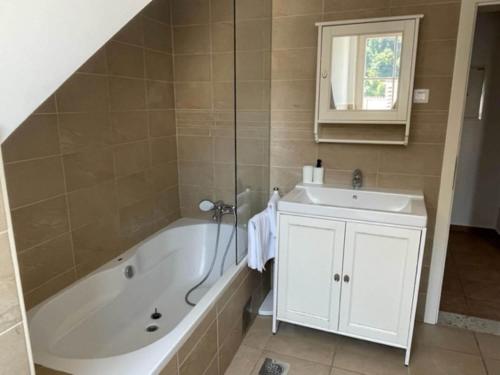 a bathroom with a tub and a sink at Duplex Apartment Main Square in Kamnik