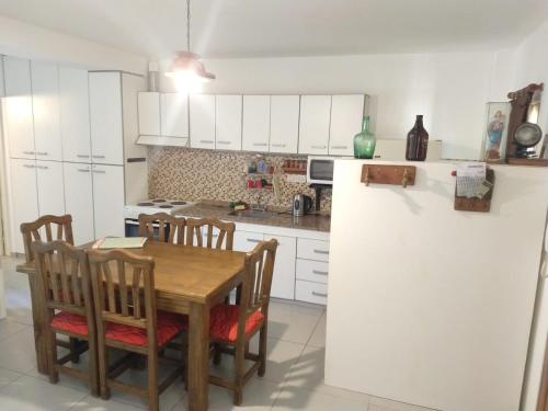 una cocina con armarios blancos y una mesa y sillas de madera. en TAMBO LIBERTADOR, en San Juan