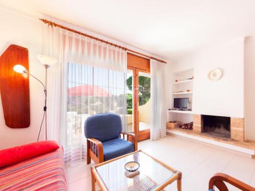 a living room with a blue chair and a glass table at Apartment Melis III by Interhome in Pals