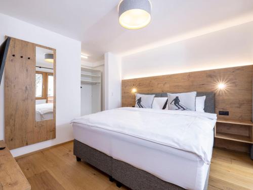 ein Schlafzimmer mit einem großen weißen Bett und einem Spiegel in der Unterkunft Apartment Apartments Austria-8 by Interhome in Söll