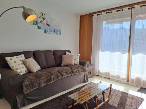 Una sala de estar con un sofá y una mesa de cristal. en Apartment Beausoleil 4 by Interhome, en Verbier