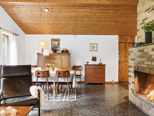 ein Esszimmer mit einem Tisch und einem Kamin in der Unterkunft Holiday Home Fulla - 650m from the sea in Sealand by Interhome in Højby