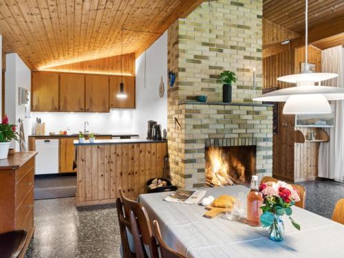 cocina y comedor con mesa y chimenea en Holiday Home Fulla - 650m from the sea in Sealand by Interhome, en Højby