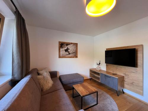 a living room with a couch and a flat screen tv at Apartment Comfort Bergblick 13 by Interhome in Söll