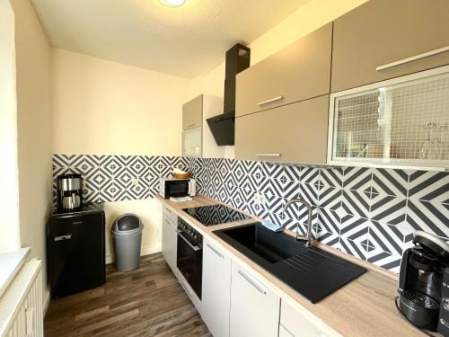 een keuken met een zwart-witte muur bij Apartment Pumphut by Interhome 
