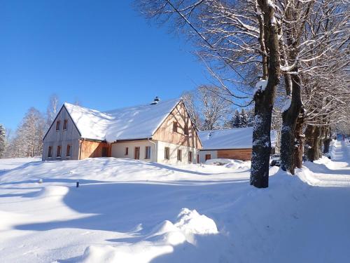 a barn covered in snow in a field at Chalet U Krále-3 by Interhome in Kořenov