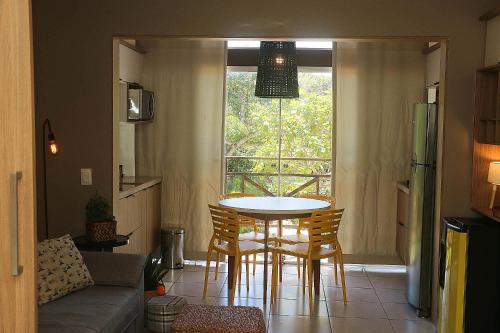 a living room with a table and chairs and a window at Ubaia charme & conforto in Pipa
