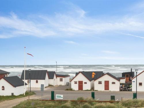 una fila de casas con el océano en el fondo en Holiday Home Unge - 75m from the sea in NW Jutland by Interhome, en Torsted