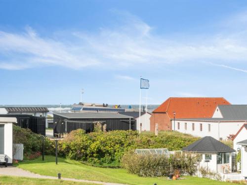 eine Gruppe von Gebäuden in einer Stadt mit einem Feld in der Unterkunft Holiday Home Unge - 75m from the sea in NW Jutland by Interhome in Torsted