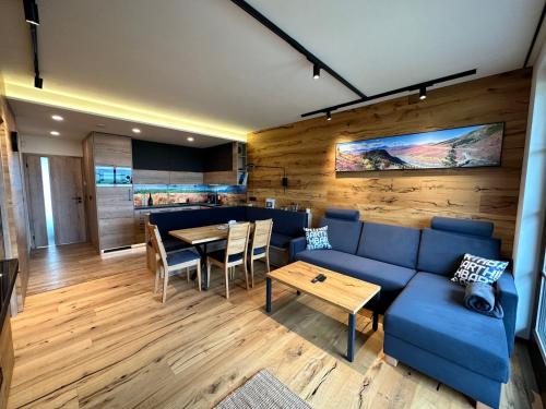 - un salon avec un canapé bleu et une table dans l'établissement Holiday Home Říčky v Orlických horách E34 by Interhome, à Říčky