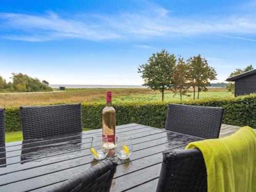een fles wijn bovenop een houten tafel bij Holiday Home Nora - 100m from the sea in SE Jutland by Interhome in Sønderby