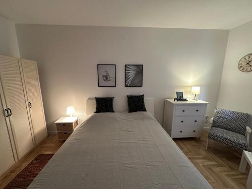 1 dormitorio con 1 cama grande con 2 lámparas y 1 silla en Optimal Apartment Sarajevo en Sarajevo