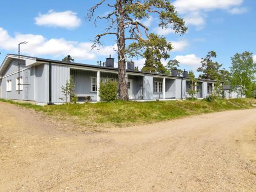 een wit huis met een boom naast een onverharde weg bij Holiday Home Saariseläntie 8 c 6 alatupa by Interhome in Saariselkä