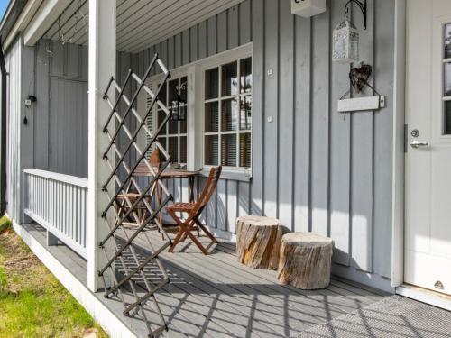 een veranda met twee stoelen en een tafel en twee blokken bij Holiday Home Saariseläntie 8 c 6 alatupa by Interhome in Saariselkä