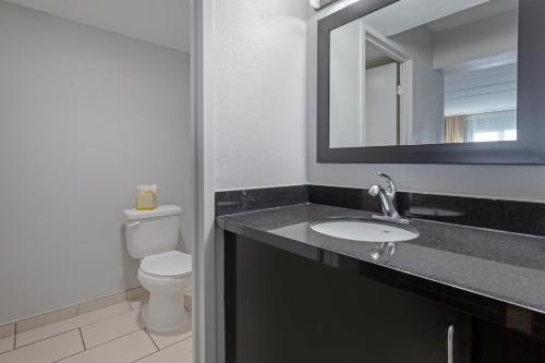 a bathroom with a sink and a toilet and a mirror at Clarion Hotel & Suites BWI Airport North in Baltimore