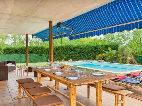 une terrasse avec une table et une piscine dans l'établissement Holiday Home Dolce by Interhome, à Caldes de Malavella