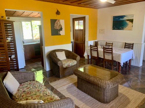 ein Wohnzimmer mit Stühlen, einem Tisch und einem Esszimmer in der Unterkunft Saint Leu - Gîte Ylang Ylang - Bardzour in Saint-Leu