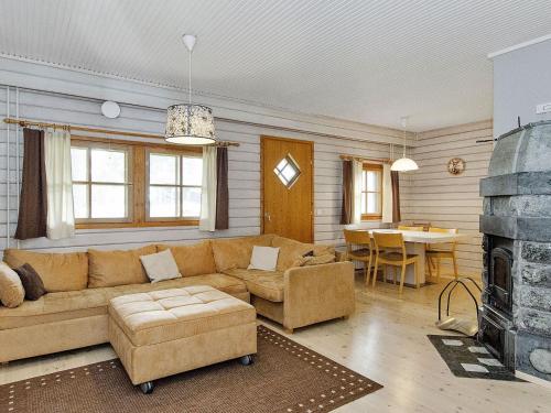 a living room with a couch and a fireplace at Holiday Home Kulta-käkönen 3 by bomba by Interhome in Nurmes