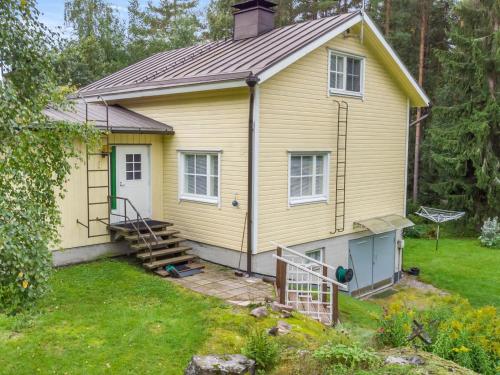 una casa gialla con portico e cortile di Holiday Home Halkoniemi by Interhome a Jämsä