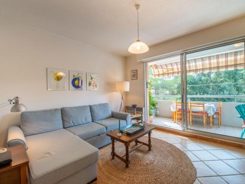 un salon avec un canapé bleu et une table dans l'établissement Apartment Aquarius by Interhome, à Cavalaire-sur-Mer