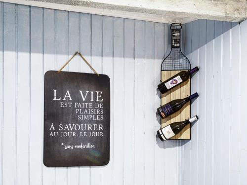 un panneau suspendu sur un mur avec des bouteilles de vin dans l'établissement Holiday Home La Salanquaise by Interhome, à Saint-Hippolyte