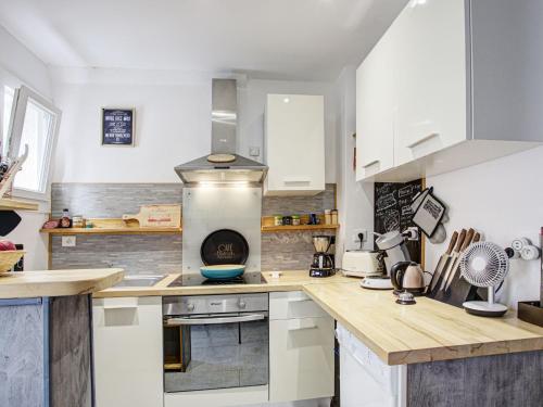 une cuisine avec des armoires blanches et des comptoirs en bois dans l'établissement Holiday Home La Salanquaise by Interhome, à Saint-Hippolyte