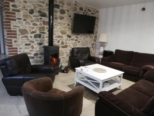 a living room with leather furniture and a fireplace at Chambres d'Hôtes des Hirondelles in Beaussais sur Mer