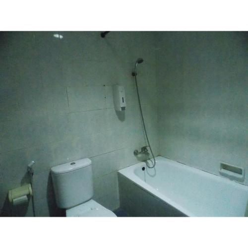 a bathroom with a toilet and a bath tub at Puri Jaya Hotel in Jakarta