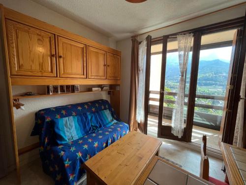 un salon avec un canapé et une grande fenêtre dans l'établissement Mini T2 à Barcelonnette pour 4 avec balcon, TV et coin-cuisine équipé - FR-1-165A-111, à Barcelonnette